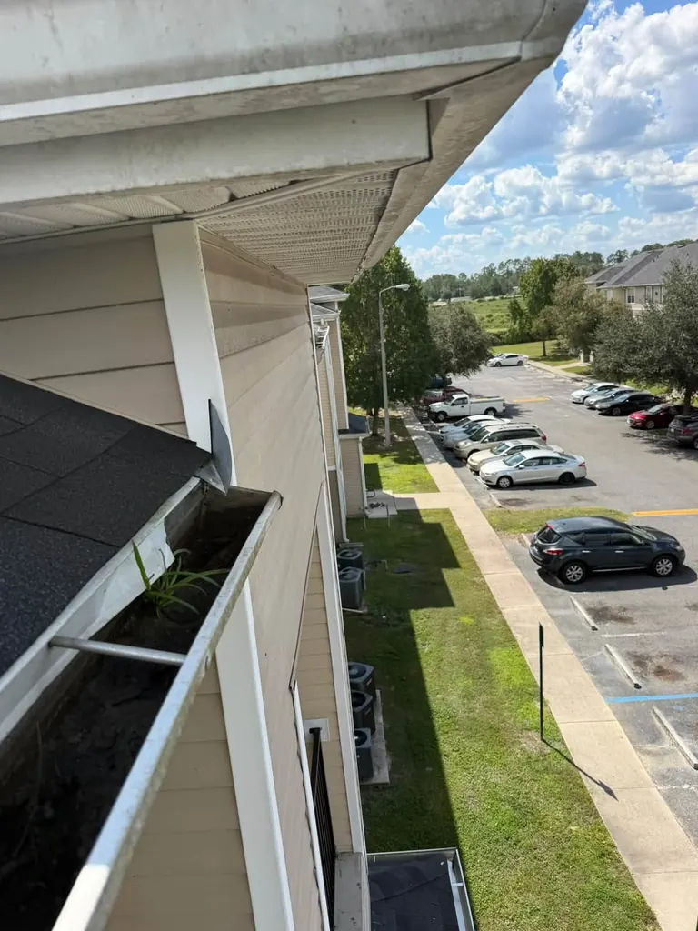 Gutter being cleaned on a balcony level